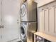 Functional laundry room features a stacked washer and dryer and a built-in bench at 6853 W Rockland Pl, Littleton, CO 80128