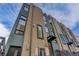 Modern townhome exterior with brick and dark gray finish, large windows, and private entry at 2442 Champa St, Denver, CO 80205