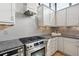 Modern kitchen details featuring stainless steel appliances, granite countertops, tile backsplash and sleek, white cabinetry at 2442 Champa St, Denver, CO 80205
