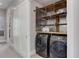 Convenient laundry room with front-load washer and dryer, complemented by wooden shelving at 2442 Champa St, Denver, CO 80205