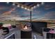 Relaxing roof deck with modern outdoor seating, a fire pit, and stunning city skyline views at sunset at 2442 Champa St, Denver, CO 80205
