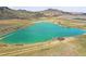 Scenic aerial view of a large lake, mountains, and a rural landscape with a building near the shore at 4309 S Coors Ct, Morrison, CO 80465
