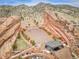 An aerial view of the iconic Red Rocks Amphitheater nestled among red rock formations and scenic mountain landscapes at 4309 S Coors Ct, Morrison, CO 80465