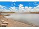 A serene lake view with a small dock, surrounded by sandy shores and clear skies on a sunny day at 4309 S Coors Ct, Morrison, CO 80465