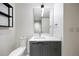 Modern bathroom with a gray vanity, white countertops, and a tiled wall mirror at 1750 Wewatta St # 1536, Denver, CO 80202