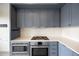Galley kitchen with stainless steel appliances, tile backsplash, and under cabinet lighting at 1750 Wewatta St # 1536, Denver, CO 80202