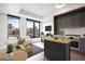 Bright, modern living room with large windows offering stunning city views, an island, and sleek, gray kitchen cabinets at 1750 Wewatta St # 1536, Denver, CO 80202