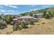 Aerial view of a sprawling home surrounded by mature trees, lush greenery, and mountain views at 10985 Ambush Rock, Littleton, CO 80125
