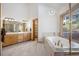 Elegant bathroom with soaking tub, wood cabinets, and double vanity at 10985 Ambush Rock, Littleton, CO 80125