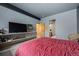 Primary bedroom featuring a red duvet, tv, shelves and a bathroom entryway at 10985 Ambush Rock, Littleton, CO 80125