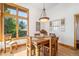 Comfortable dining room with wood table, light fixture, and lots of natural light at 10985 Ambush Rock, Littleton, CO 80125