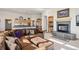 Open living space featuring a fireplace with stone surround, built-in shelving and kitchen access at 10985 Ambush Rock, Littleton, CO 80125