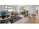 Bright living room boasts a large window, plush seating, stylish decor, and view to dining room at 10985 Ambush Rock, Littleton, CO 80125