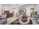Bright living room boasts plush seating, stylish decor, a view to the dining room, and staircase at 10985 Ambush Rock, Littleton, CO 80125