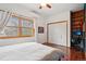 Sunny bedroom with hardwood floors, ceiling fan, built-in shelving and large window at 1927 Pine St # B, Boulder, CO 80302