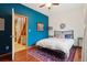 Bedroom with hardwood floors, ceiling fan, and unique blue accent wall at 1927 Pine St # B, Boulder, CO 80302