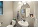 Well-lit half bath with an oval mirror and modern fixtures at 15352 E 117Th Ave, Commerce City, CO 80022