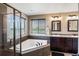 Bright bathroom features a luxurious soaking tub, walk-in shower, and double vanity sinks at 15352 E 117Th Ave, Commerce City, CO 80022