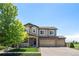 Charming two-story home with a well-manicured lawn, a three-car garage, and stone accents at 15352 E 117Th Ave, Commerce City, CO 80022