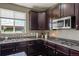 Kitchen featuring granite countertops, dark cabinetry, stainless steel appliances and lots of natural light at 15352 E 117Th Ave, Commerce City, CO 80022