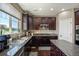 Open concept kitchen with dark cabinets, granite countertops, stainless appliances and hardwood floors at 15352 E 117Th Ave, Commerce City, CO 80022