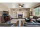 Cozy living room with a stone fireplace, plush seating, and abundant natural light at 15352 E 117Th Ave, Commerce City, CO 80022