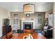 Inviting living room featuring a stone fireplace and modern lighting fixture for a cozy ambiance at 15352 E 117Th Ave, Commerce City, CO 80022