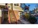 Multi-level condo building with red brick accents and a charming wooden staircase leading to the entrance at 919 S Dawson Way # 7, Aurora, CO 80012