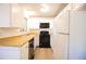 Efficient kitchen with white cabinets and appliances, complete with wood-look countertops at 919 S Dawson Way # 7, Aurora, CO 80012