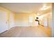 An open living area with light hardwood floors flowing into an adjacent white kitchen at 919 S Dawson Way # 7, Aurora, CO 80012