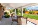 Covered back patio features seating area, neutral-colored pillars, and views of the backyard and lawn at 5593 E Center Ave, Denver, CO 80246