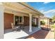 Comfortable patio space with a shade covering, brick accents, and a pleasant view of the backyard at 5593 E Center Ave, Denver, CO 80246