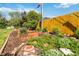 Backyard garden bed with rich vegetation and mulch coverage, while the yellow fence encloses the space for added privacy at 5593 E Center Ave, Denver, CO 80246