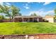 Lush backyard featuring a vibrant green lawn, mature trees, a shaded patio area, and a sturdy wooden fence at 5593 E Center Ave, Denver, CO 80246