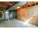 Exposed basement with concrete walls, wooden support beams, water heater and access to stairs at 5593 E Center Ave, Denver, CO 80246
