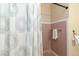 Bathroom featuring retro pink tile and updated shower curtain at 5593 E Center Ave, Denver, CO 80246