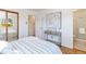 Bright bedroom featuring a console table, neutral decor, and an en suite bathroom at 5593 E Center Ave, Denver, CO 80246