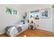 Bright bedroom featuring hardwood floors, a large window, and a decorative painting at 5593 E Center Ave, Denver, CO 80246