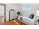 Bedroom featuring hardwood floors, a large window, and dresser storage at 5593 E Center Ave, Denver, CO 80246