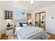 Bright bedroom featuring a tufted headboard, plush rug, and mirrored closet doors at 5593 E Center Ave, Denver, CO 80246