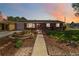 Charming brick home featuring a beautifully landscaped front yard at sunset at 5593 E Center Ave, Denver, CO 80246