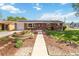Charming brick home featuring a beautifully landscaped front yard and solar panels on the roof at 5593 E Center Ave, Denver, CO 80246