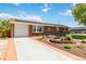 Charming brick home featuring a driveway and beautifully landscaped front yard at 5593 E Center Ave, Denver, CO 80246