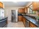 Updated kitchen with stainless steel appliances, tiled backsplash, and tile floors at 5593 E Center Ave, Denver, CO 80246