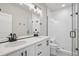 Elegant bathroom with double sinks, a large mirror, and a glass-enclosed shower with white subway tiles at 17673 Brass Buckle Way, Monument, CO 80132