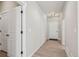 Hallway leading to the front door, with two white doors and light colored wood floors at 17673 Brass Buckle Way, Monument, CO 80132