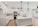 Modern kitchen with white cabinets, quartz countertops, stainless steel appliances, and stylish pendant lighting at 17673 Brass Buckle Way, Monument, CO 80132