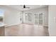 Bright living room featuring light wood floors, modern ceiling fan, and large windows overlooking the backyard at 17673 Brass Buckle Way, Monument, CO 80132