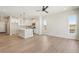 Light-filled open living space with wood floors leading into a kitchen with white cabinets and modern finishes at 17673 Brass Buckle Way, Monument, CO 80132