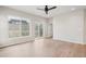 Spacious living room with light wood floors, a ceiling fan, and a sliding glass door to access the backyard at 17673 Brass Buckle Way, Monument, CO 80132